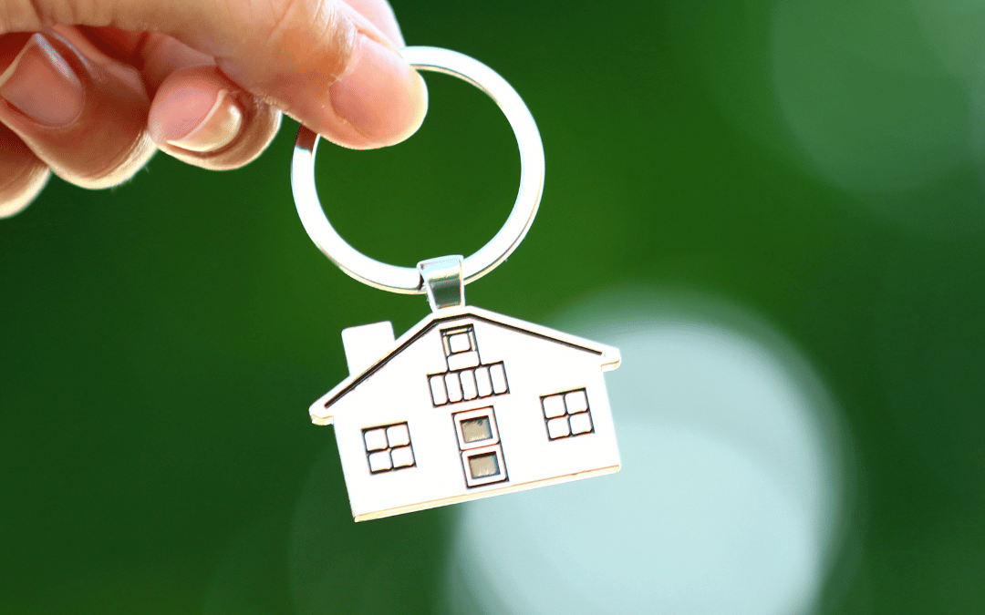 Image of someone holding a keychain that has a house on it.
